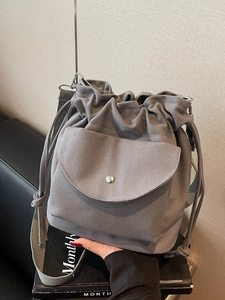 Borsa a secchiello in tela grigia con coulisse e tracolla larga regolabile sul davanti