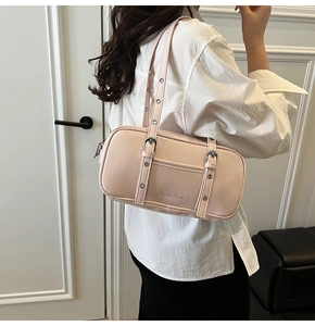Detail of adjustable strap with metallic eyelets on a pink leather shoulder bag