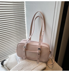 Detail of pink Boston bag featuring silver eyelet straps and smooth PU leather finish