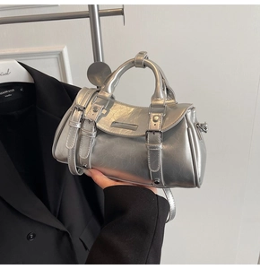 Detail of silver dumpling bag with crackle texture leather and metallic finish in studio setting