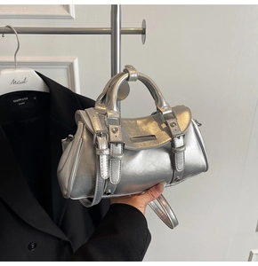 Detail of silver metallic handbag featuring pleated faux leather and Y2K hardware