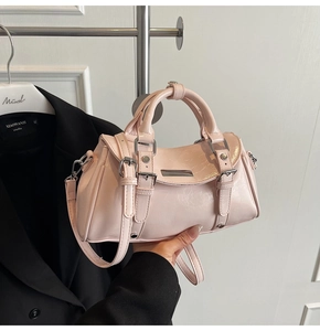 Detail of pink patent leather handbag with glossy texture and silver hardware