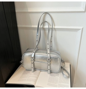 Detail of silver crinkled leather Boston bag featuring metal eyelets and buckle accents