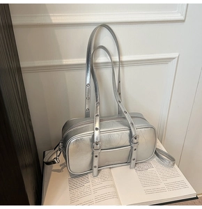 Detail of silver metallic textured Boston bag with eyelet straps and crackle finish leather