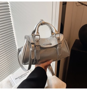 Detail of silver metallic dumpling bag showing pleated texture and sleek metal buckle