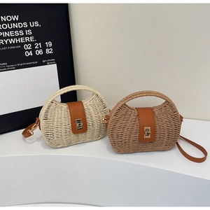 Detail of woven straw handbags with leather flap and metal twist lock on white platform