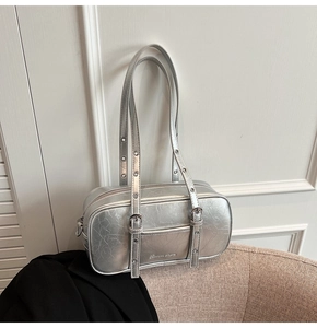 Detail of silver metallic Boston bag with cracked texture and adjustable eyelet straps