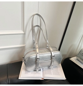 Detailed view of silver metallic Boston bag with eyelet straps and brand logo detail