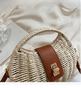 Detail of hand-woven straw bag with premium brown leather flap and golden twist lock closure