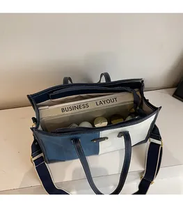 Detail view of denim tote bag showing spacious inner compartments and fabric strap