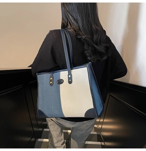 Detail of the tri-color patchwork tote bag featuring denim fabric and leather corner guards