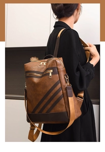 Detail eines braunen Vintage-Rucksacks mit diagonalen Streifen und abnehmbarem Gurt
