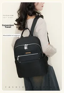Detail of waterproof black nylon backpack showing the functional luggage strap for travel