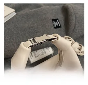 Détail de la poignée en cuir blanc crème avec des finitions métalliques argentées