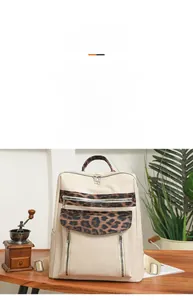 Detail of leopard print trim on ivory PU backpack with multiple zipper pockets