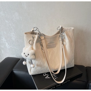 Detail of cream pleated tote bag with chain strap and cute cloud plush charm
