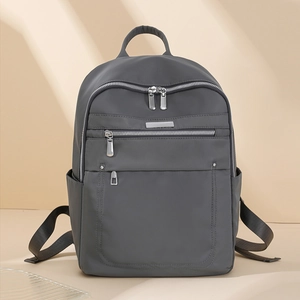Detailed view of deep grey water-resistant nylon backpack with smooth texture and silver zippers