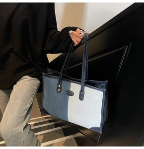 Close-up of denim tote bag featuring blue patchwork fabric and white contrast stitching