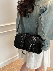 Chic black patent leather Boston bag with silver buckles and adjustable shoulder strap