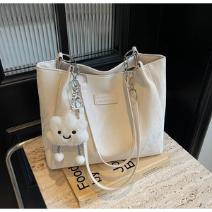 Macro shot of off-white tote bag with pleated texture and cloud plush charm detail