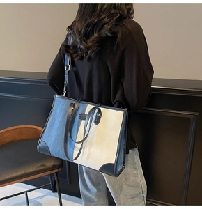Detail of blue denim and white canvas tote bag with adjustable leather shoulder strap