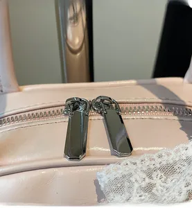 Close-up of premium dual silver zippers on a pink leather bowling shoulder bag