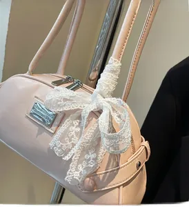 Detail of light pink leather bowling bag featuring elegant white floral lace ribbon and silver hardware