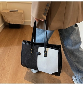 Close-up of contrast color tote bag with gold rivet details and premium metal hardware