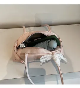 Pink bowling shoulder bag showing large interior capacity with phone and umbrella