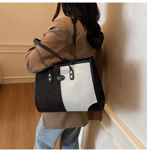 Detail showing the large capacity contrast color tote bag with leather straps on a model