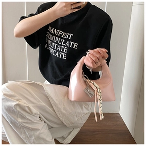 Sac à main croissant en cuir verni rose brillant avec détail nœud et pendentif métal