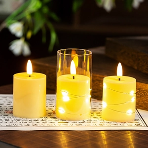 Close-up of three LED flameless candles with warm yellow light and silver fairy light strings
