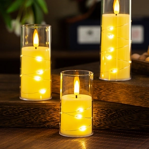 Three warm LED flameless candles in glass cylinders with copper wire string lights