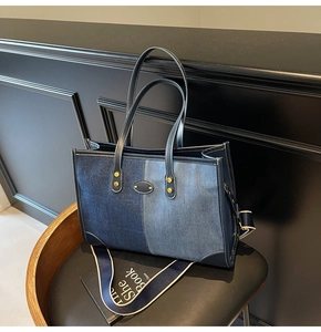 Detail of contrast patchwork denim tote bag with leather handles and gold metal tag