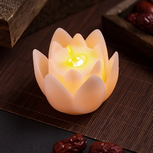 Detail view of lotus LED candle with warm glow on bamboo mat for zen decor