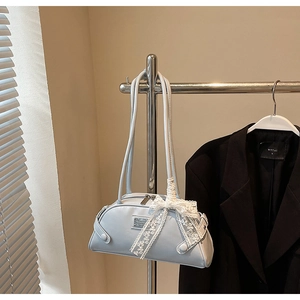 Detail of light blue bowling bag with silver plaque and white lace ribbon bow