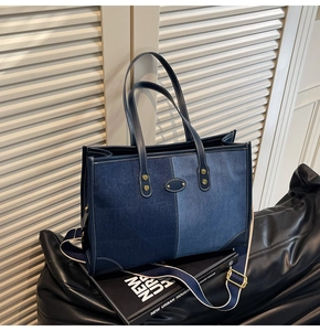 Detail of denim patchwork tote bag with gold rivets and striped adjustable strap