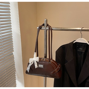 Detail of vintage brown leather bowling bag with white lace bow and silver hardware