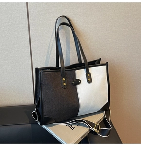 Detail view of large patchwork tote bag featuring gold rivets and woven shoulder strap