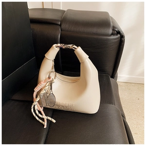 Détail d'un sac à main crème avec logo MIAOSHE et pendentifs de raquette de tennis