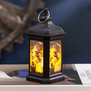 Detail view of Halloween lantern featuring warm glowing witch and bat pattern panels