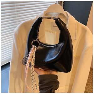 Détail du sac hobo noir verni avec lettrage en relief et breloque raquette de tennis