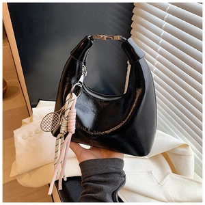 Détail du sac hobo noir brillant avec boucle argentée et breloque raquette de tennis