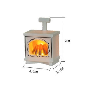 Detailed view of white miniature dollhouse fireplace with orange LED glowing charcoal
