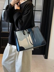 Three-tone patchwork denim tote bag with black leather trim and gold hardware details