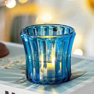 Detailed close-up of blue ribbed crystal glass candle holder with warm LED light glow