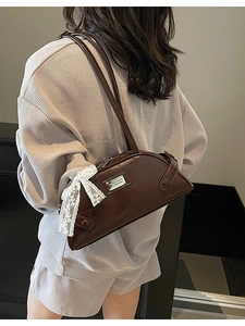Dark brown glossy underarm bowling bag with white lace bow and metallic plate detail