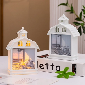 House-shaped night light with warm sunset scene and metal hanging ring on books