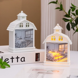 Detail of a house-shaped LED night light with warm yellow glow and bedroom scene
