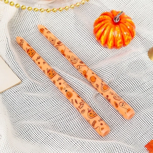 Pair of 25cm orange taper candles with Halloween pumpkin and ghost prints for decor